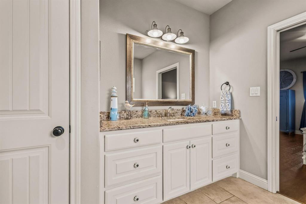 293 Redden Road Van Alstyne, TX 75495 - Photo 29 of 40 a bathroom with a granite countertop sink vanity and mirror