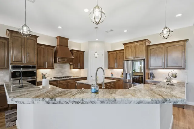 a large kitchen with granite countertop a stove and a sink