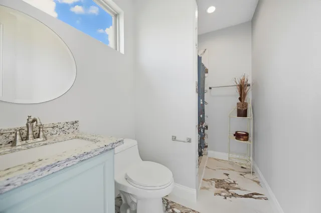 a bathroom with a granite countertop sink and a mirror