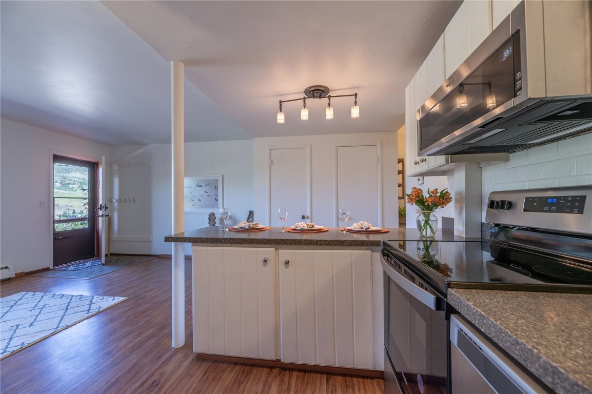 110 Evergreen Road, Unit 102 Dillon, CO 80435 - Photo 23 of 30 a kitchen with stainless steel appliances granite countertop a sink and wooden cabinets