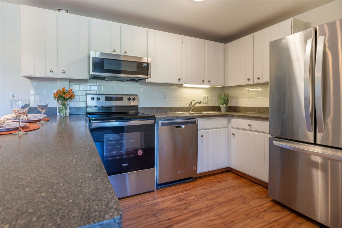 110 Evergreen Road, Unit 102 Dillon, CO 80435 - Photo 25 of 30 a kitchen with granite countertop a refrigerator stove and white cabinets
