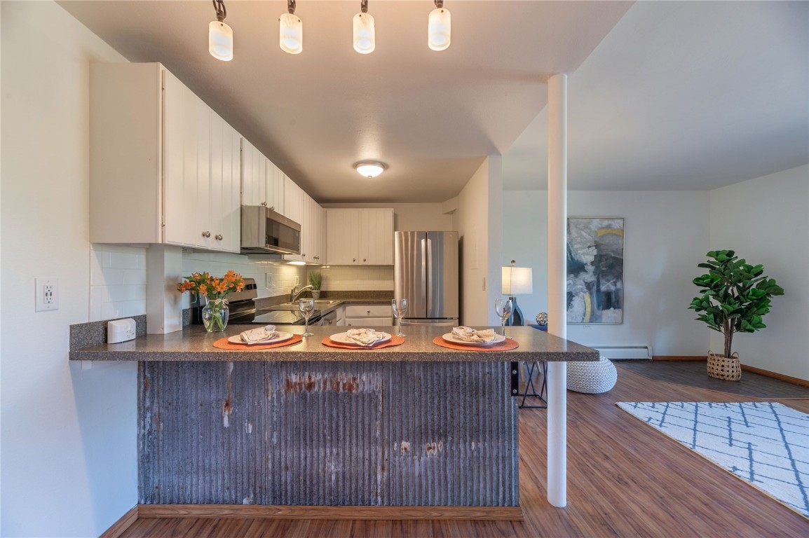 110 Evergreen Road, Unit 102 Dillon, CO 80435 - Photo 4 of 30 a kitchen with stainless steel appliances granite countertop a sink dishwasher a stove a refrigerator a stove with wooden floor
