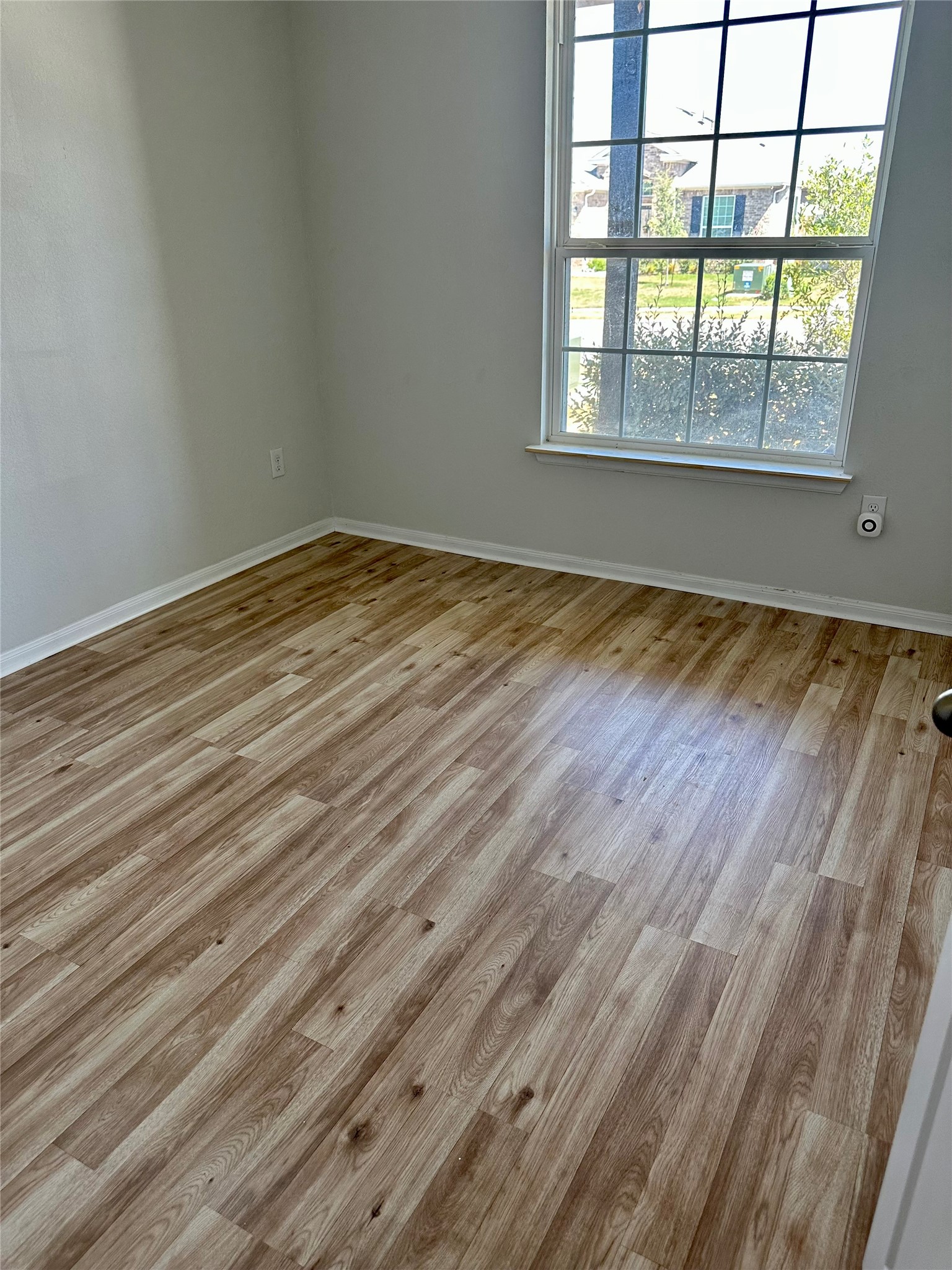 1003 Cherrystone Loop Buda, TX 78610 - Photo 18 of 27 an empty room with wooden floor and windows