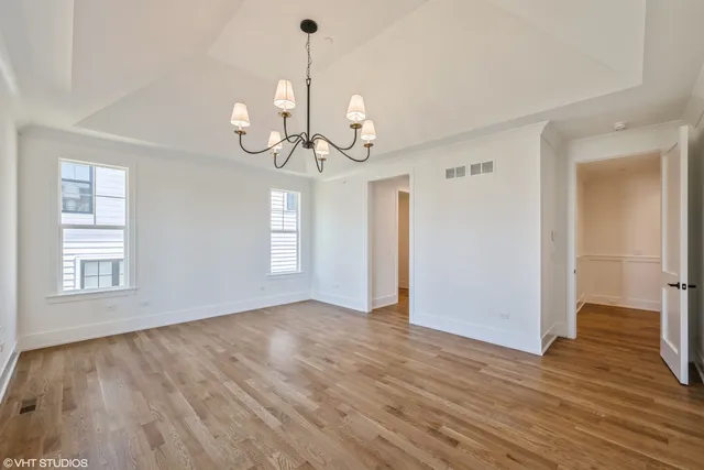 a view of an empty room with wooden floor and windows