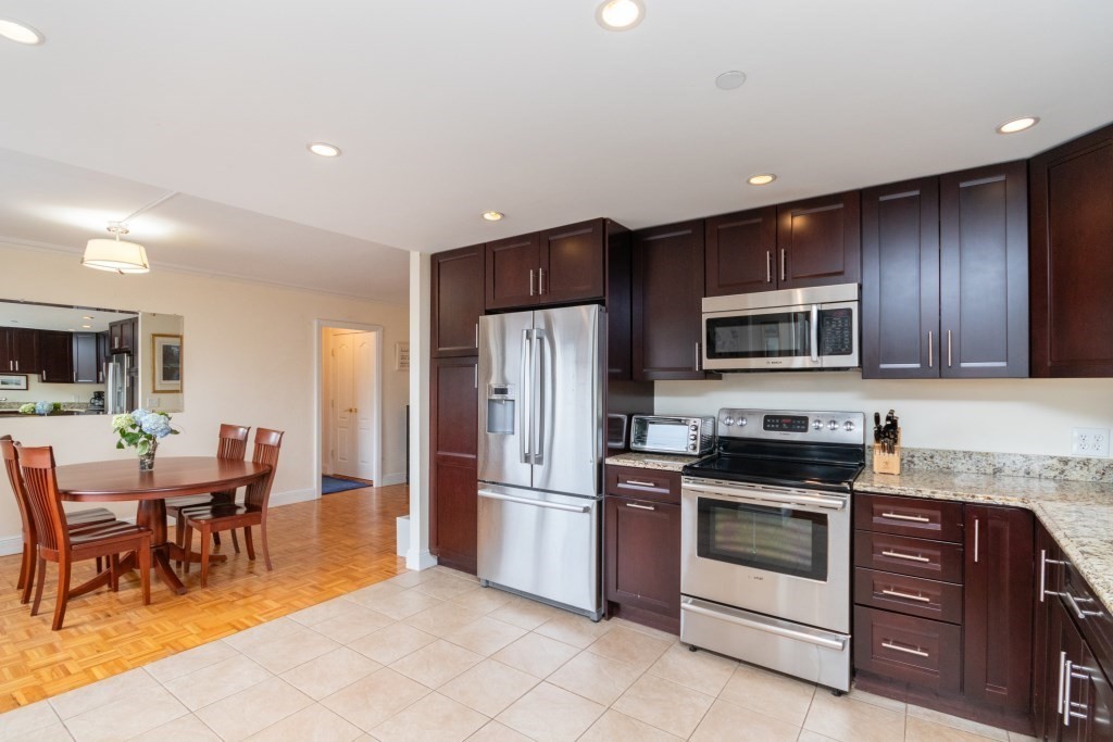 a kitchen with granite countertop appliances cabinets and chairs