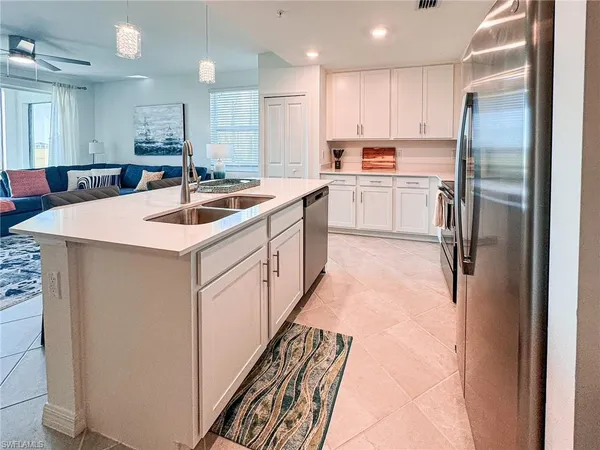 a kitchen with kitchen island a sink stainless steel appliances and cabinets