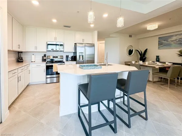 a large kitchen with cabinets table and chairs