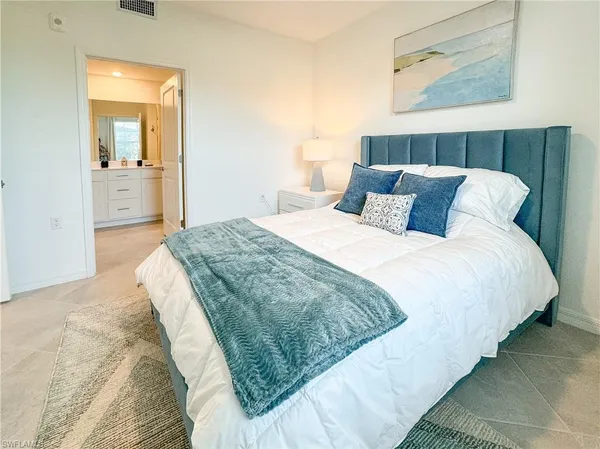 a spacious bedroom with a bed and a mirror