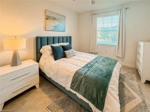 a bed sitting in a bedroom next to a window
