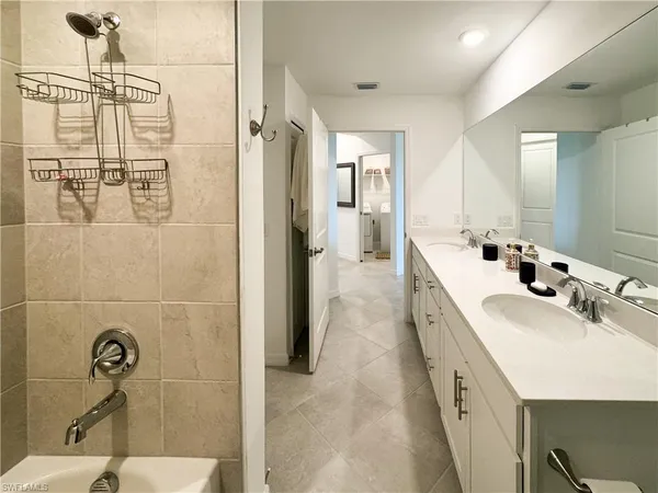 a bathroom with a double vanity sink a mirror and shower