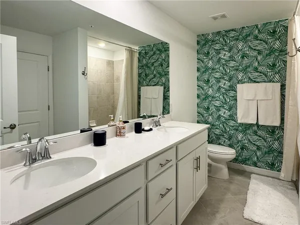 a bathroom with double sink and a mirror