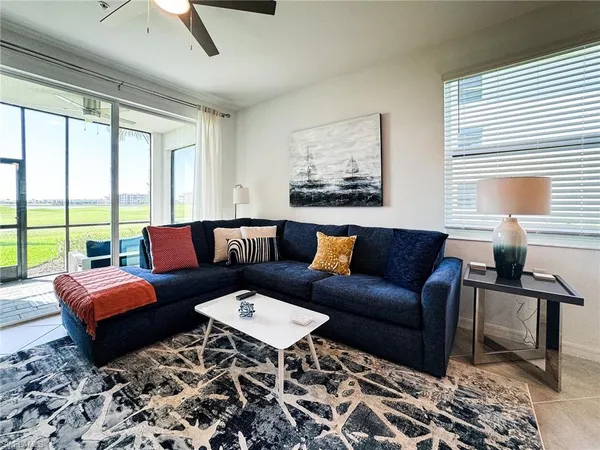 a living room with furniture wooden floor and a large window