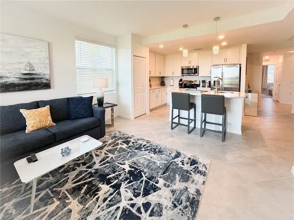 a living room with a couch and kitchen view with wooden floor