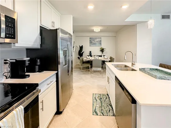 a kitchen that has a lot of cabinets a sink and appliances in it