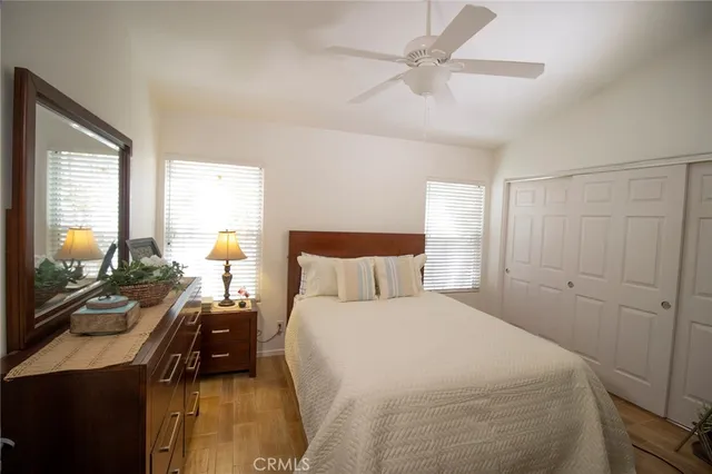 a bedroom with a bed a chandelier and a flat tv screen