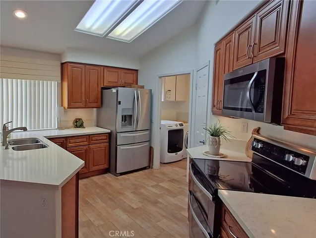 a kitchen with granite countertop a sink stainless steel appliances and cabinets