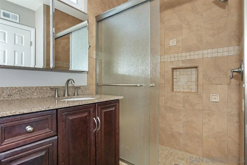13130 Tobiasson Road Poway, CA 92064 - Photo 18 of 24 a bathroom with a granite countertop sink a toilet and a mirror