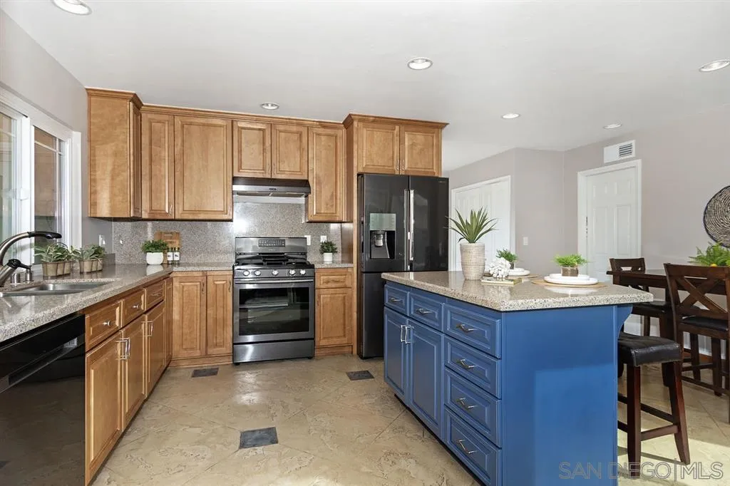 13130 Tobiasson Road Poway, CA 92064 - Photo 8 of 24 a kitchen with granite countertop wooden cabinets and stainless steel appliances