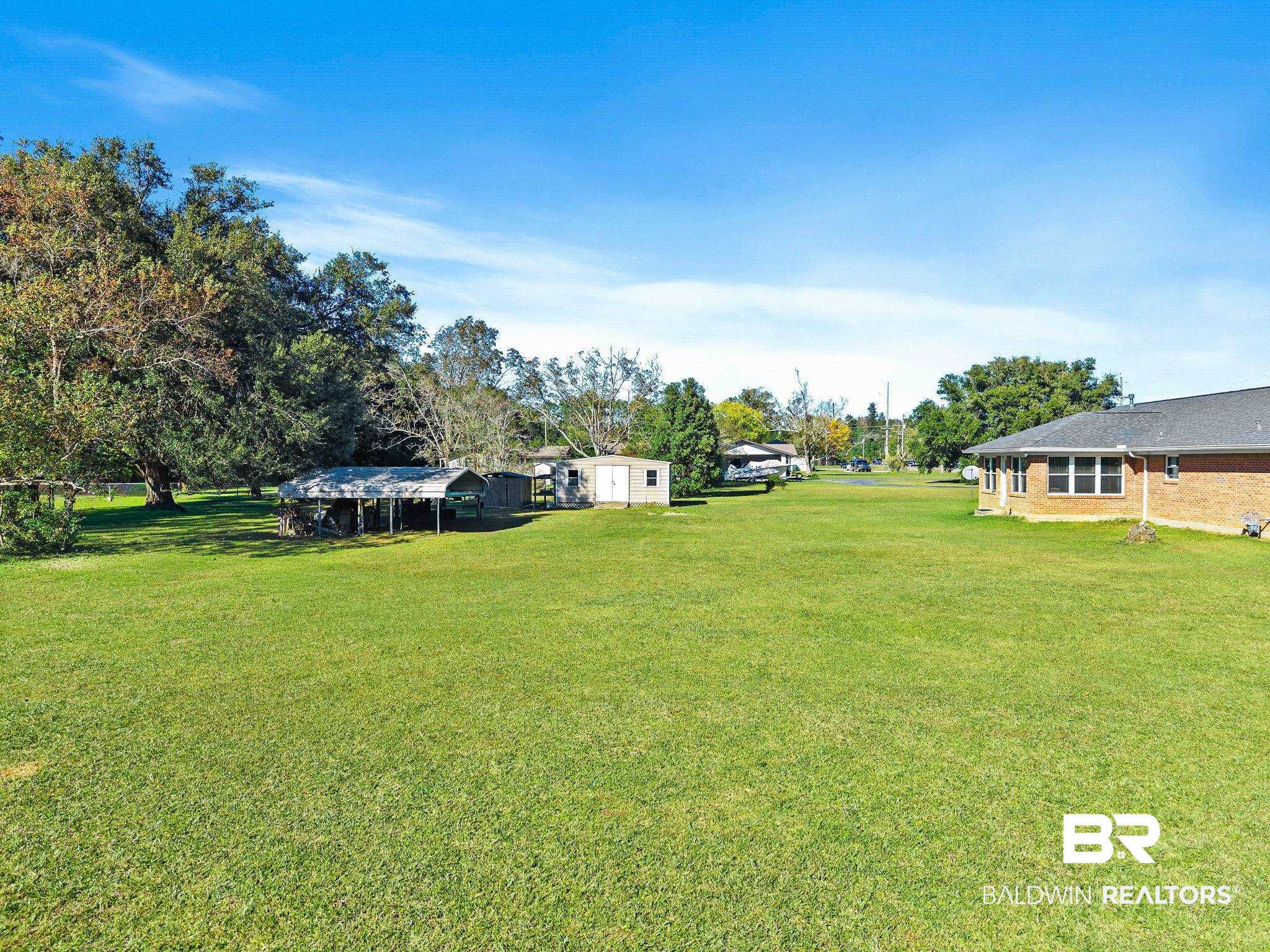 1510 South Juniper Street Foley, AL 36535 - Photo 35 of 36 View of grassy yard featuring a detached carport and view of scattered trees