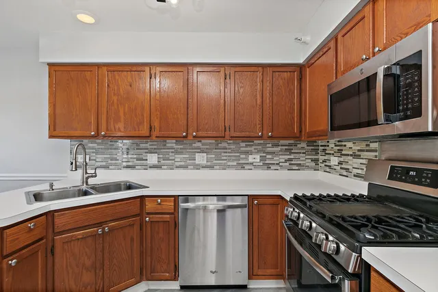 a kitchen with stainless steel appliances a stove a sink microwave and cabinets