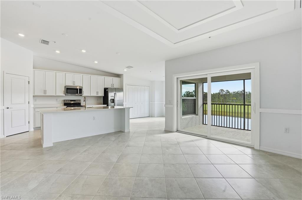 15185 Bluffton Lane, Unit 826 Punta Gorda, FL 33982 - Photo 12 of 50 a large white kitchen with white cabinets and a refrigerator