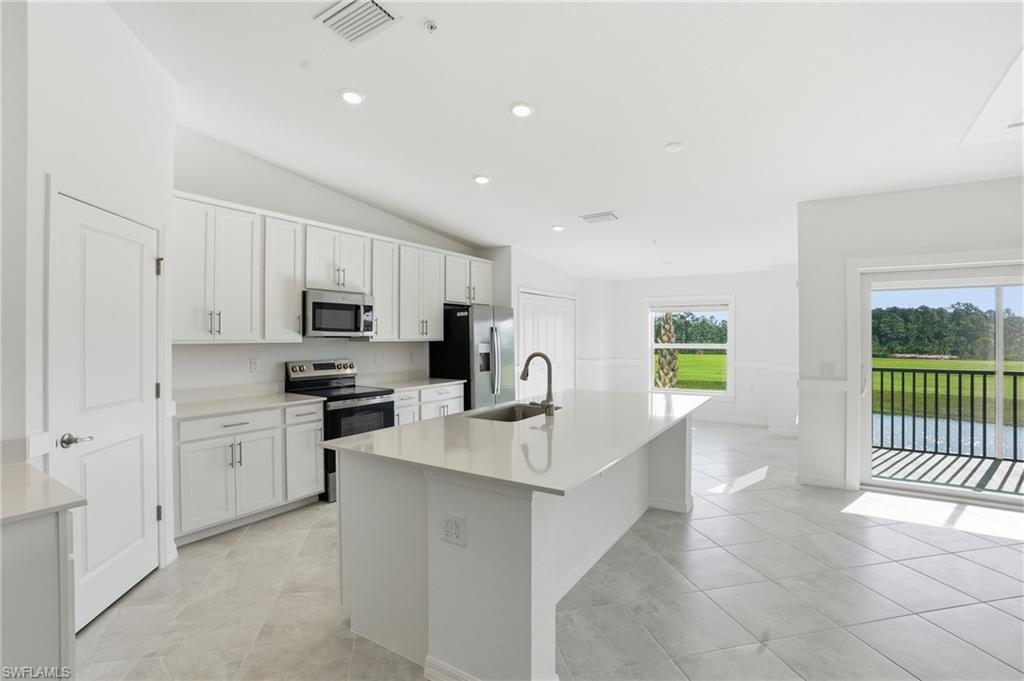 15185 Bluffton Lane, Unit 826 Punta Gorda, FL 33982 - Photo 15 of 50 a kitchen with white cabinets and appliances