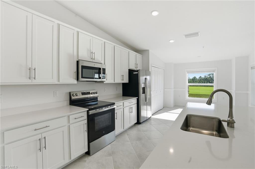 15185 Bluffton Lane, Unit 826 Punta Gorda, FL 33982 - Photo 17 of 50 a kitchen with white cabinets and stainless steel appliances