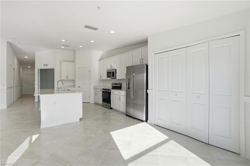 15185 Bluffton Lane, Unit 826 Punta Gorda, FL 33982 - Photo 22 of 50 a large kitchen with cabinets and stainless steel appliances