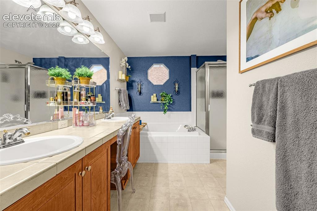 9127 Oakmont Road Peyton, CO 80831 - Photo 21 of 49 a bathroom with a sink a vanity a mirror a bathtub and window