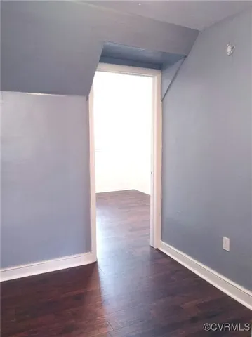 a view of a small space with wooden floor and a window