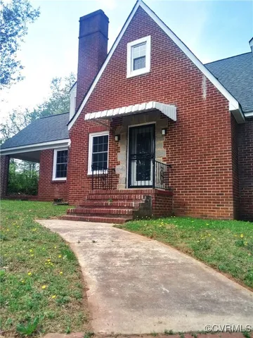a view of a brick house with a yard