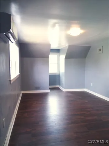a view of empty room with window and wooden floor