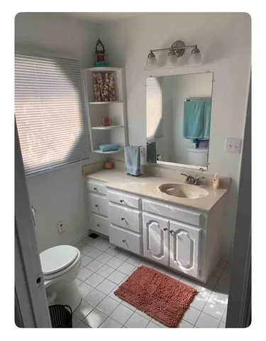 a bathroom with a sink a toilet and mirror