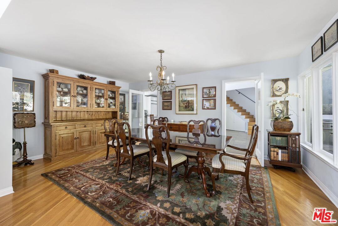 11215 Sunset Boulevard Los Angeles, CA 90049 - Photo 23 of 74 a dining room with furniture a rug and wooden floor