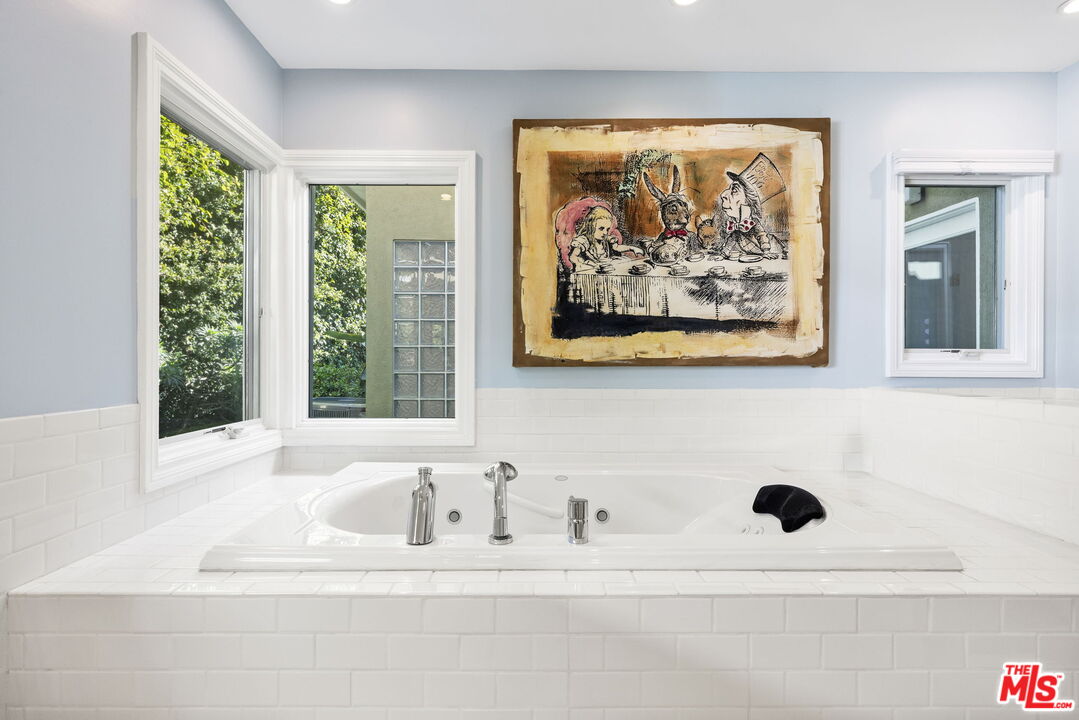 11215 Sunset Boulevard Los Angeles, CA 90049 - Photo 45 of 74 a bathroom with a bathtub and a window