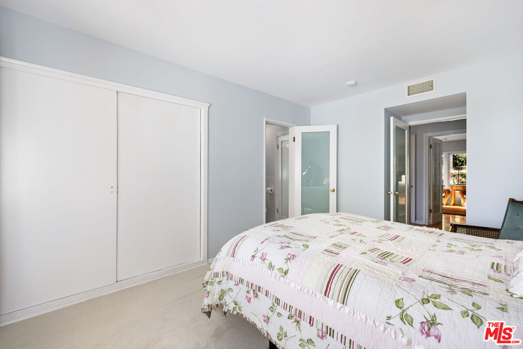 11215 Sunset Boulevard Los Angeles, CA 90049 - Photo 53 of 74 a bedroom with a bed and a mirror