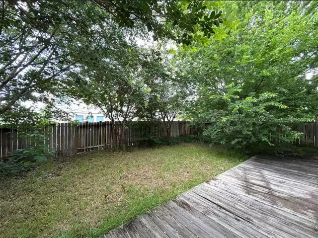 a backyard of a house with lots of plants and tree