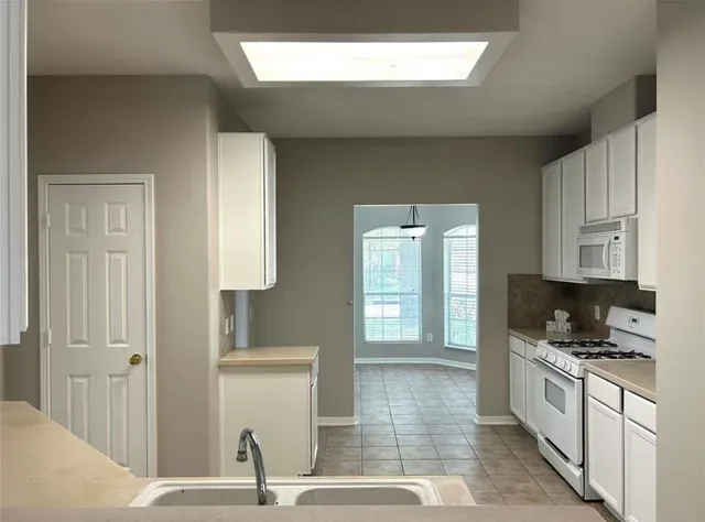a kitchen with granite countertop a sink and a stove top oven
