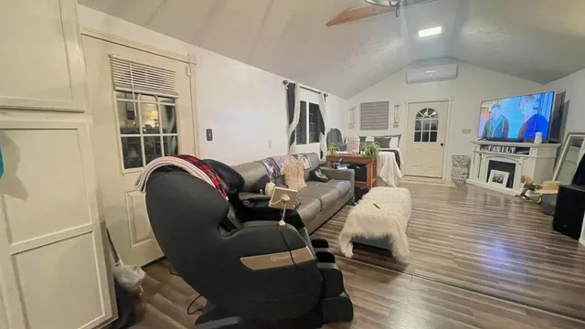 a living room with furniture flat screen tv and wooden floor