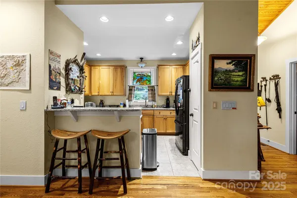 a view of a kitchen with granite countertop a refrigerator and a sink