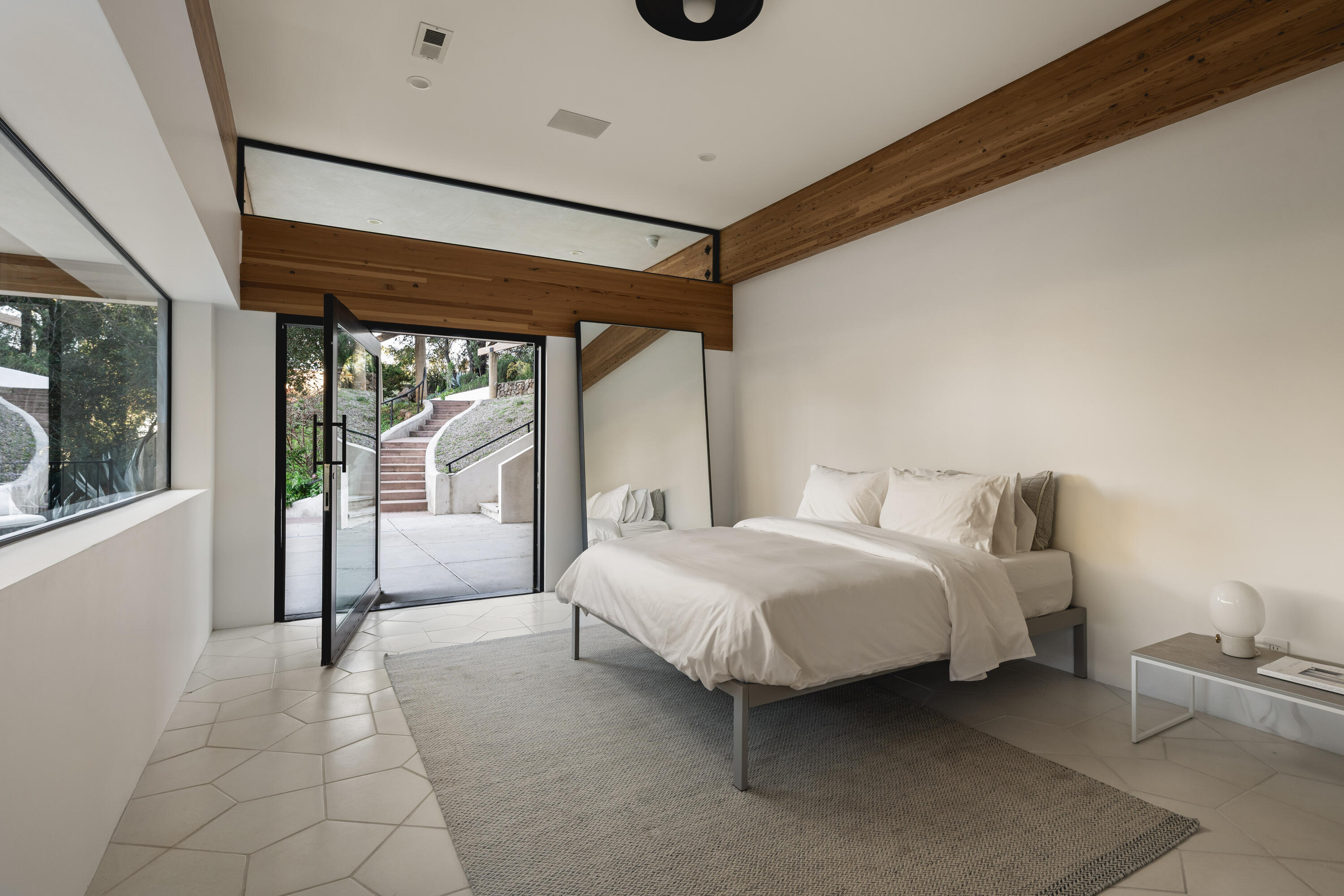 2315 Live Oak Meadows Road Malibu, CA 90265 - Photo 25 of 32 a spacious bedroom with a bed and a window