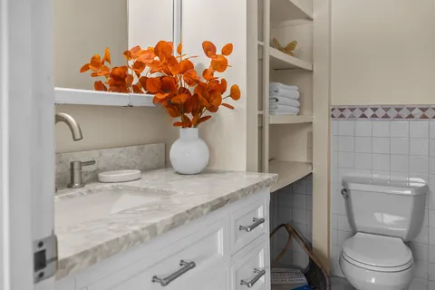 a bathroom with a granite countertop sink a toilet and a shower curtain
