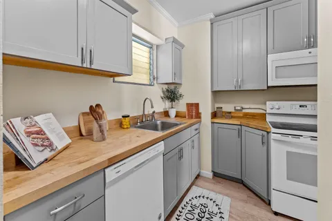 a kitchen with stainless steel appliances granite countertop a sink dishwasher a stove and cabinets with wooden floor