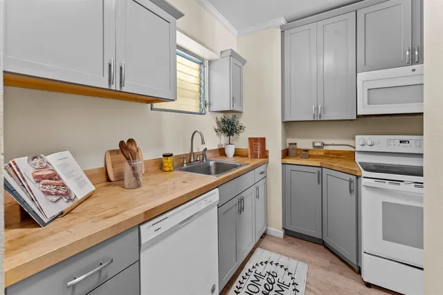 a kitchen with stainless steel appliances granite countertop a sink dishwasher a stove and cabinets with wooden floor