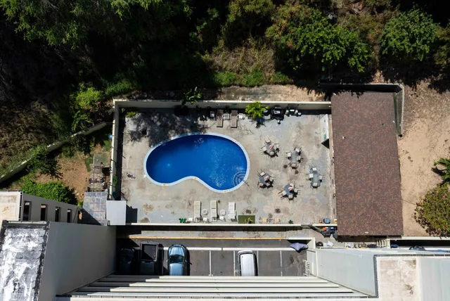 an aerial view of a house with a yard and large trees