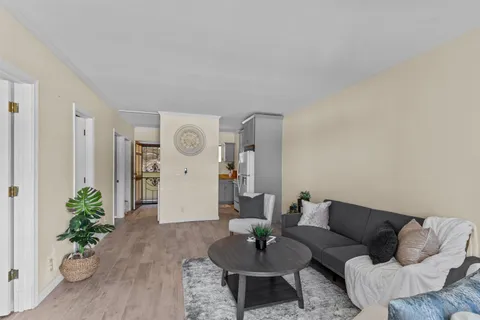 a living room with furniture and wooden floor