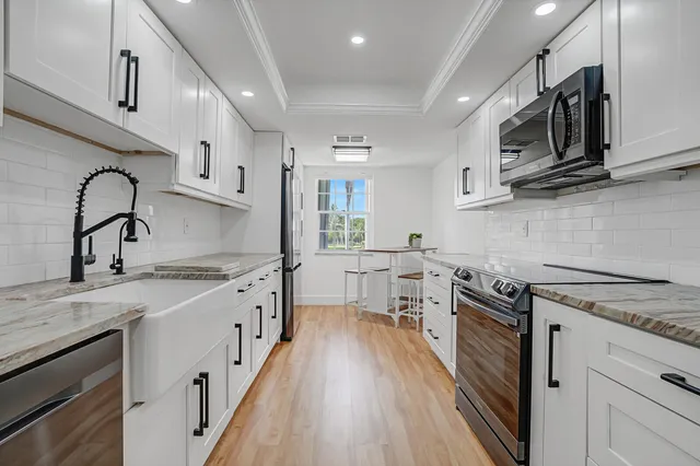 a kitchen with stainless steel appliances granite countertop a sink stove and refrigerator