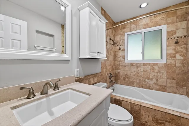 a bathroom with a sink toilet vanity and bathtub