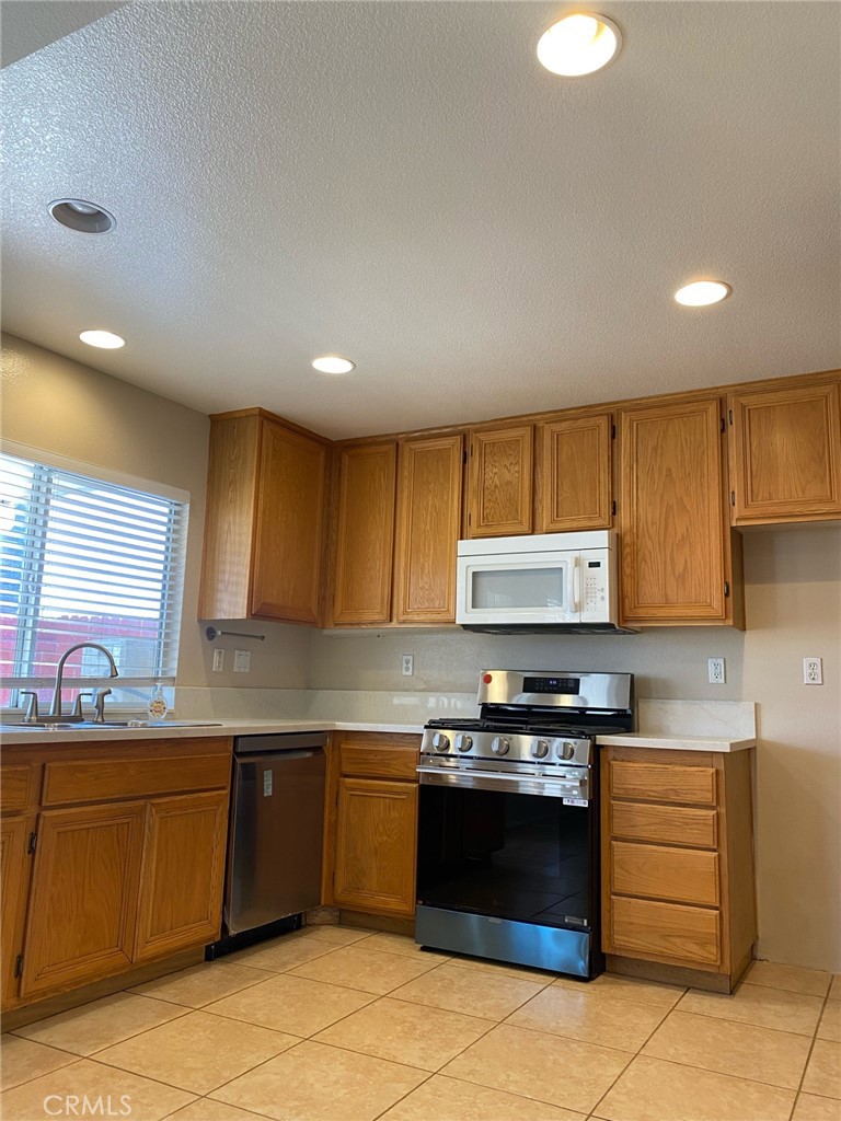250 Settlers Road Upland, CA 91786 - Photo 15 of 31 a kitchen with stainless steel appliances granite countertop a stove a sink and a refrigerator