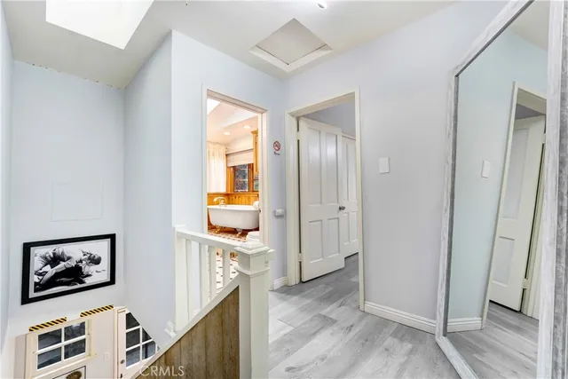 a view of a hallway with wooden floor and windows